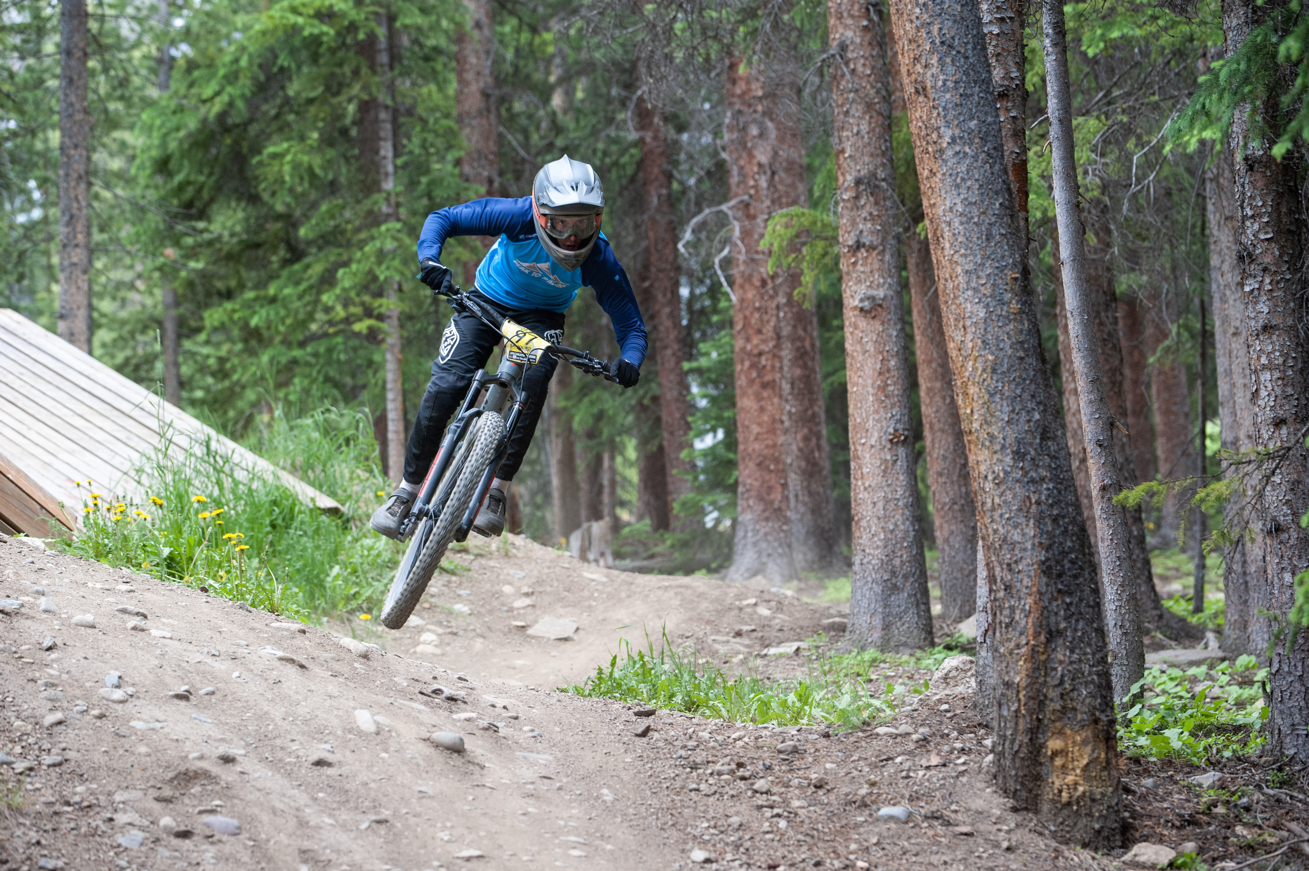 Peak 10 rider cornering through a forest trail