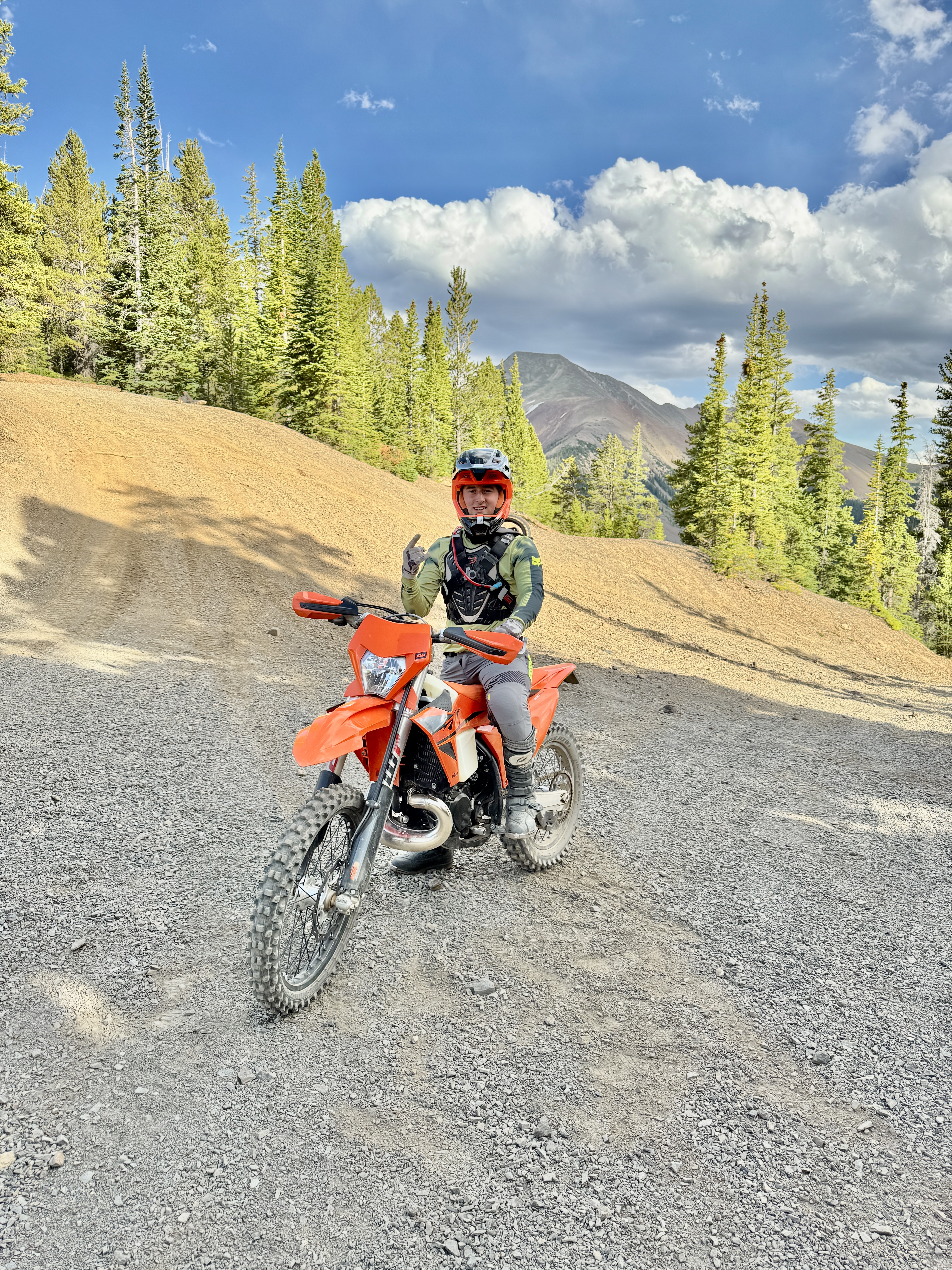 Peak 10 rider on a mountain bike with mountains in the background